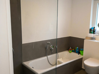 Badezimmer-Duschwand#1 Glas-Duschwand mit Badewanne im Hintergrund